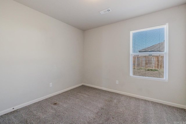 carpeted empty room with visible vents and baseboards