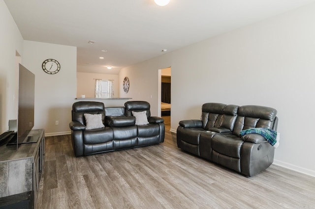 living area with baseboards and wood finished floors