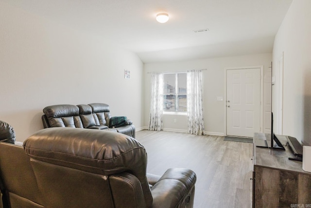 living room with visible vents, light wood-type flooring, and baseboards