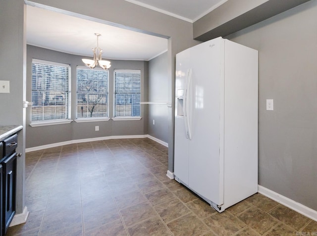 kitchen featuring a notable chandelier, white refrigerator with ice dispenser, crown molding, light countertops, and baseboards