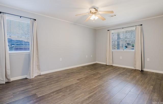 spare room with visible vents, crown molding, baseboards, wood finished floors, and a ceiling fan