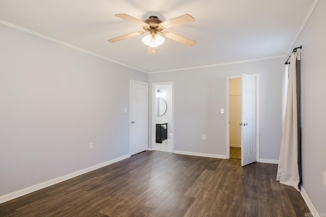 unfurnished bedroom with a barn door, dark wood-style floors, baseboards, and ornamental molding