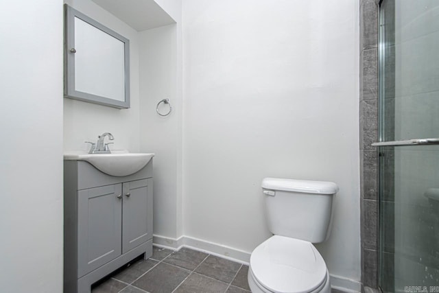 bathroom featuring a shower with door, baseboards, toilet, tile patterned floors, and vanity