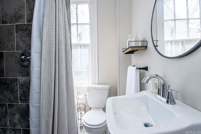 bathroom featuring a sink, a shower with curtain, and toilet