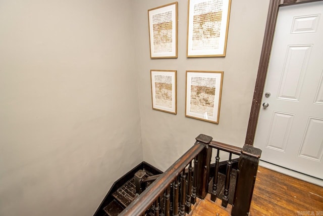 hall with an upstairs landing and wood finished floors