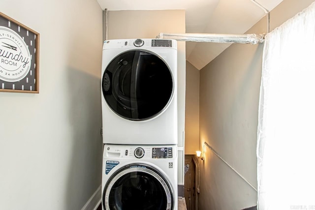 clothes washing area featuring laundry area and stacked washer / dryer