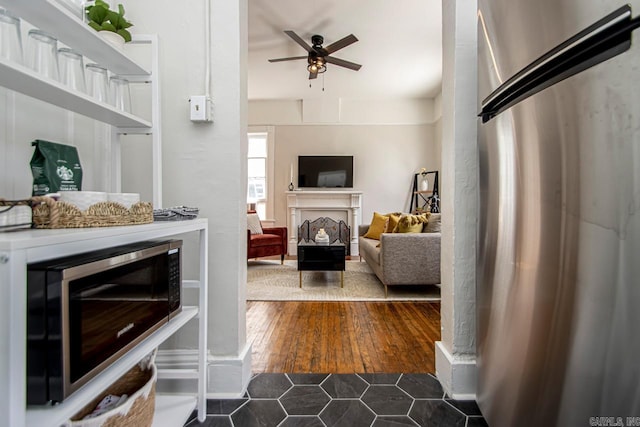 living room featuring ceiling fan and dark wood-style flooring