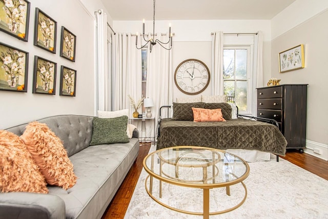 bedroom with a notable chandelier, dark wood-type flooring, and baseboards