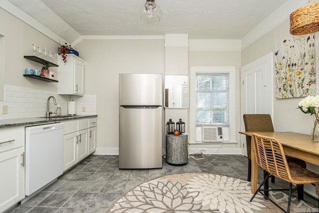 kitchen featuring dishwasher, decorative backsplash, cooling unit, freestanding refrigerator, and a sink