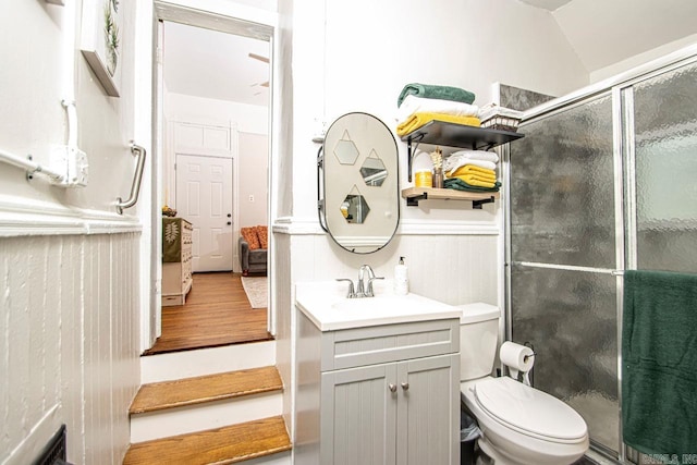 bathroom with vanity, wood finished floors, ensuite bath, a stall shower, and toilet