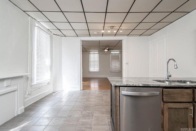 kitchen with light stone countertops, ceiling fan, a sink, a paneled ceiling, and dishwasher