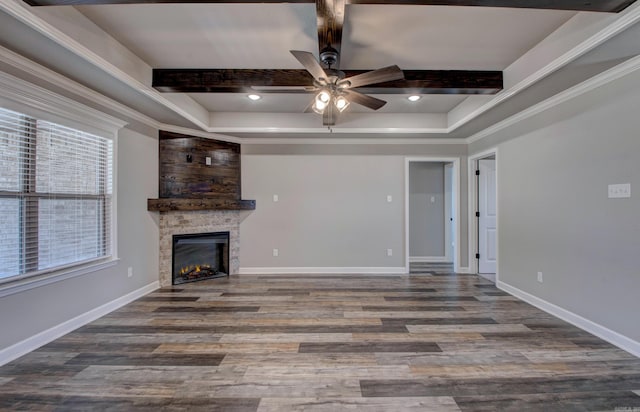 unfurnished living room with beamed ceiling, a fireplace, baseboards, and wood finished floors