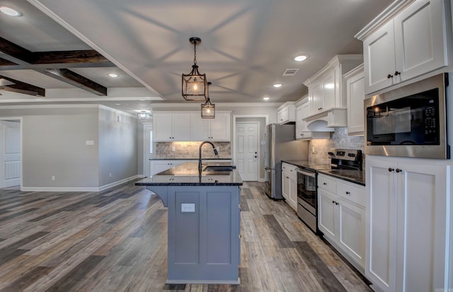 kitchen featuring visible vents, built in microwave, a sink, dark wood-type flooring, and stainless steel range with electric stovetop