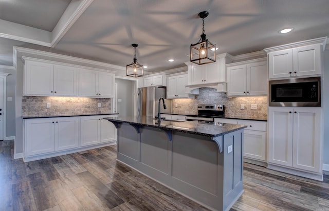 kitchen featuring stainless steel appliances, a kitchen bar, and white cabinetry