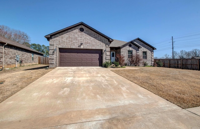 french country inspired facade featuring a garage, brick siding, concrete driveway, and fence