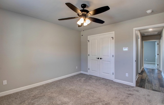 unfurnished bedroom featuring a ceiling fan, visible vents, baseboards, a closet, and carpet flooring