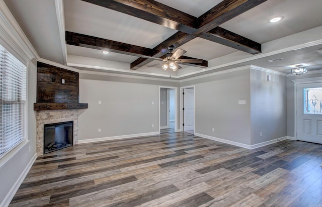 unfurnished living room featuring beamed ceiling, a fireplace, baseboards, and wood finished floors