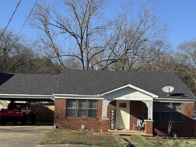 view of front of property featuring an attached carport, brick siding, roof with shingles, and covered porch