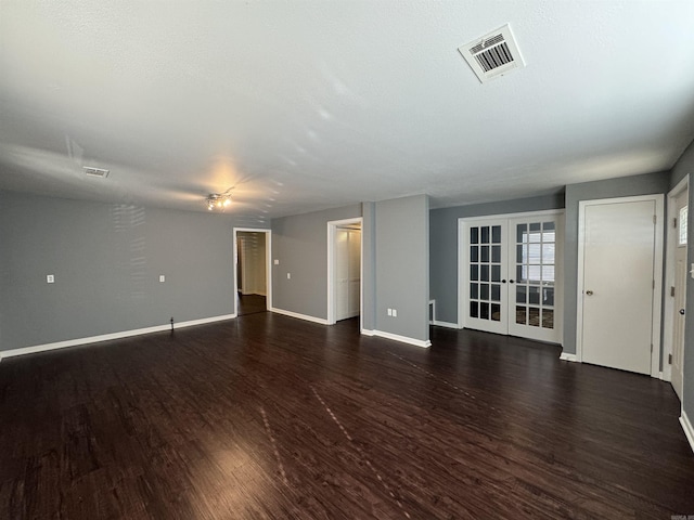 spare room featuring visible vents, baseboards, dark wood finished floors, and french doors