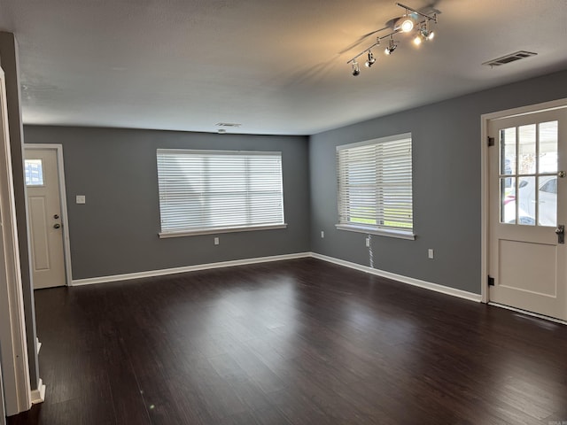 entryway featuring dark wood-type flooring, plenty of natural light, baseboards, and visible vents