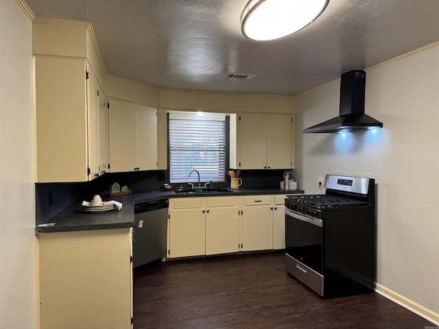 kitchen featuring dark wood-type flooring, a sink, dark countertops, stainless steel appliances, and wall chimney exhaust hood