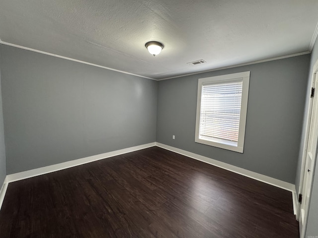 unfurnished room featuring baseboards, visible vents, ornamental molding, dark wood-type flooring, and a textured ceiling