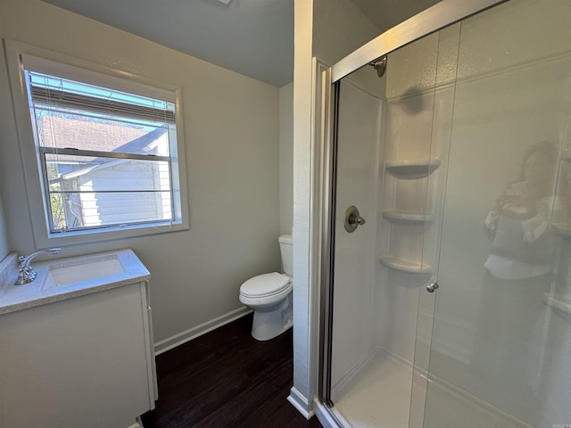 full bathroom with a shower stall, toilet, wood finished floors, and baseboards