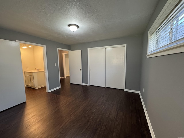 unfurnished bedroom featuring a closet, baseboards, and dark wood-style flooring