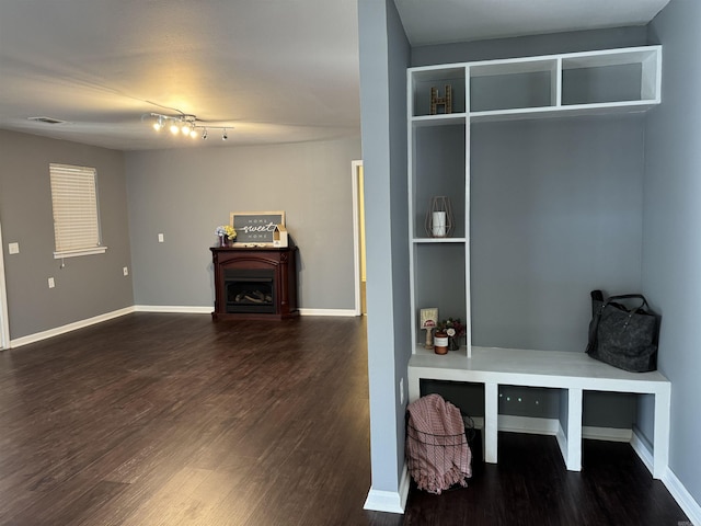 mudroom featuring visible vents, baseboards, wood finished floors, and a fireplace