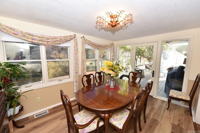 dining room featuring visible vents, baseboards, and wood finished floors