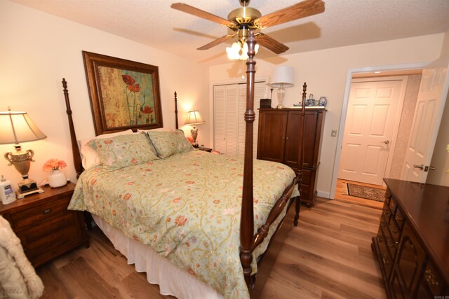 bedroom featuring a closet, a textured ceiling, and wood finished floors