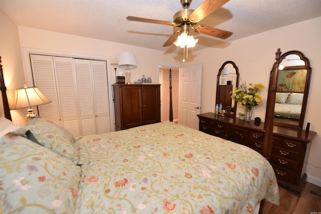 bedroom featuring a closet, a textured ceiling, wood finished floors, and a ceiling fan