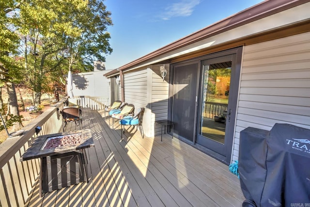 deck featuring an outdoor fire pit and grilling area