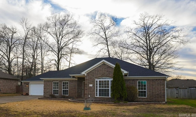 view of front of house featuring a garage, fence, and brick siding