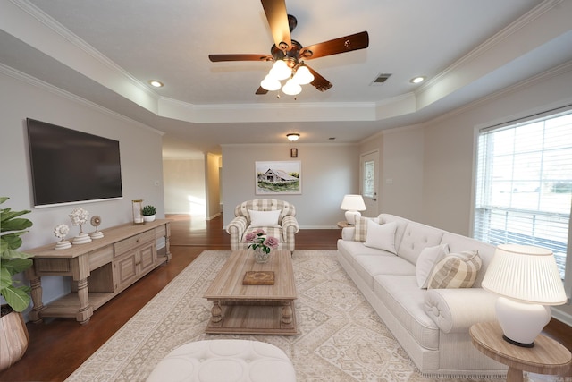 living room featuring visible vents, crown molding, a raised ceiling, and wood finished floors