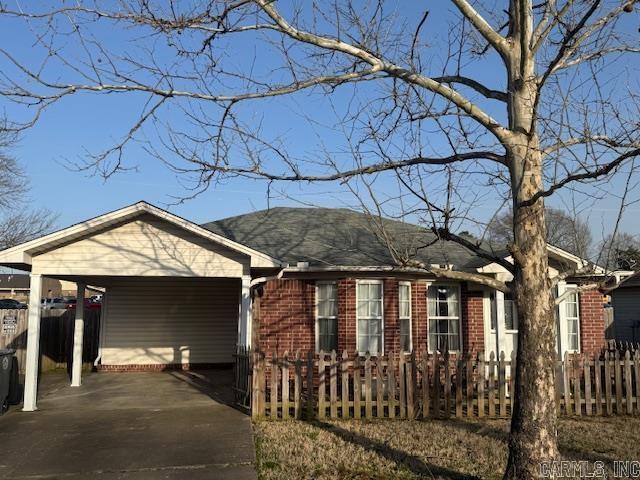 view of front of house with a fenced front yard, brick siding, and driveway