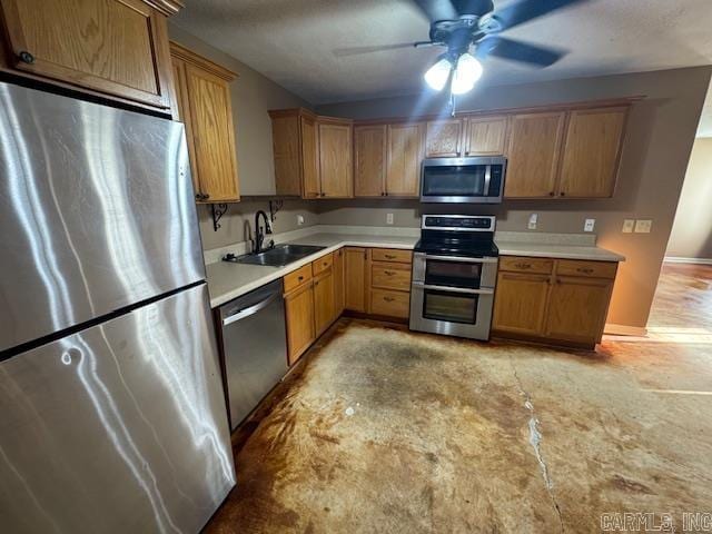 kitchen featuring a sink, stainless steel appliances, brown cabinetry, light countertops, and ceiling fan