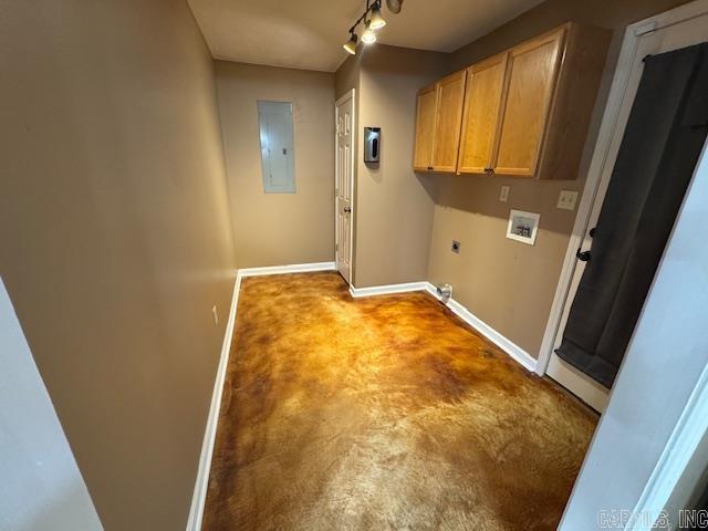 clothes washing area featuring electric dryer hookup, washer hookup, electric panel, cabinet space, and baseboards