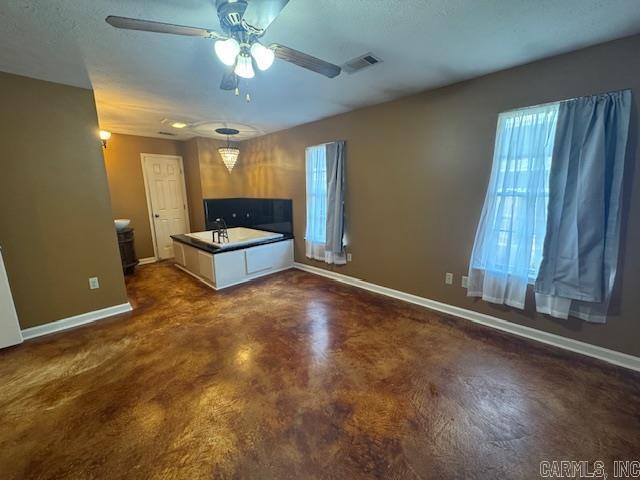 kitchen with hanging light fixtures, visible vents, baseboards, and finished concrete floors