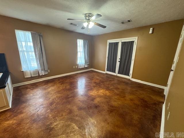 interior space featuring a textured ceiling, visible vents, baseboards, and finished concrete floors