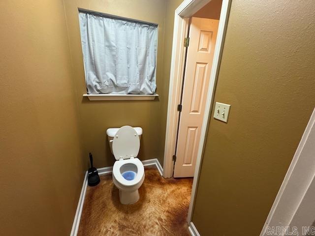 bathroom with toilet and baseboards