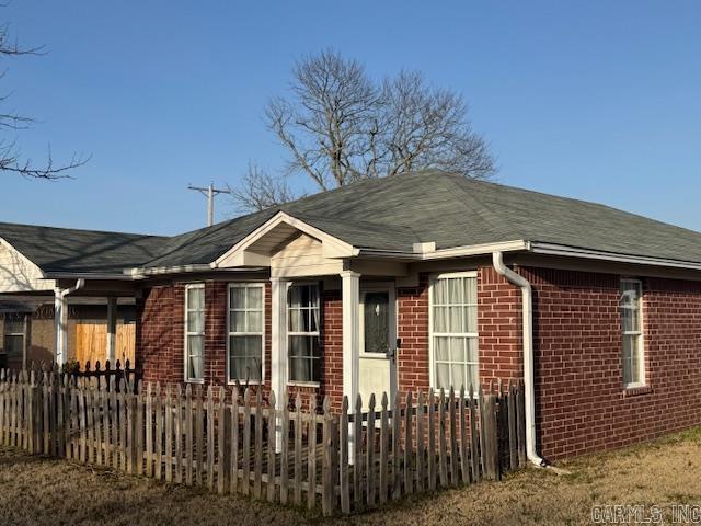 view of home's exterior featuring brick siding and fence