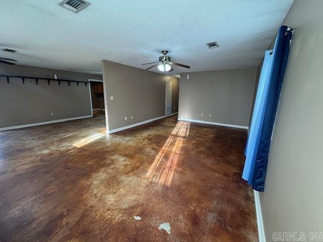 unfurnished room with a textured ceiling, baseboards, visible vents, and ceiling fan