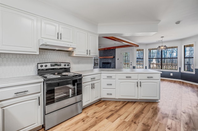 kitchen featuring white cabinetry, stainless steel electric range oven, a wealth of natural light, and under cabinet range hood