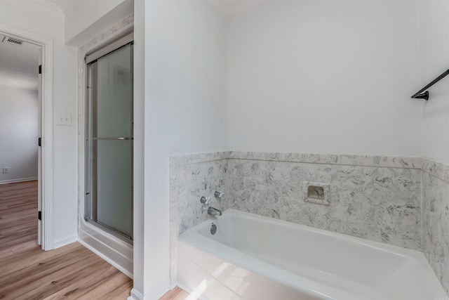 full bathroom featuring visible vents, baseboards, a stall shower, wood finished floors, and a bath