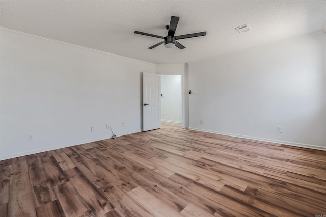 spare room featuring visible vents, crown molding, ceiling fan, wood finished floors, and a textured ceiling