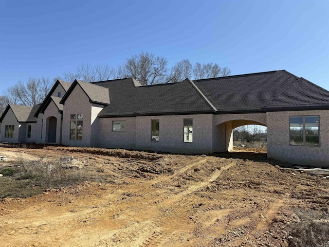 french country home with a shingled roof