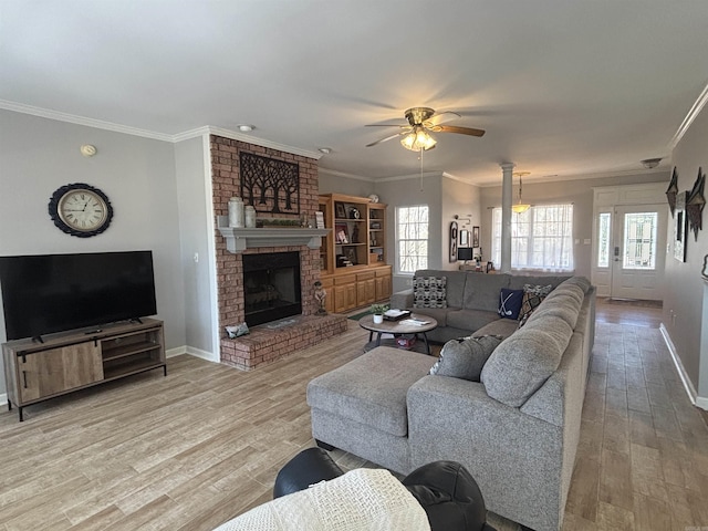 living area featuring crown molding, a healthy amount of sunlight, and light wood-type flooring