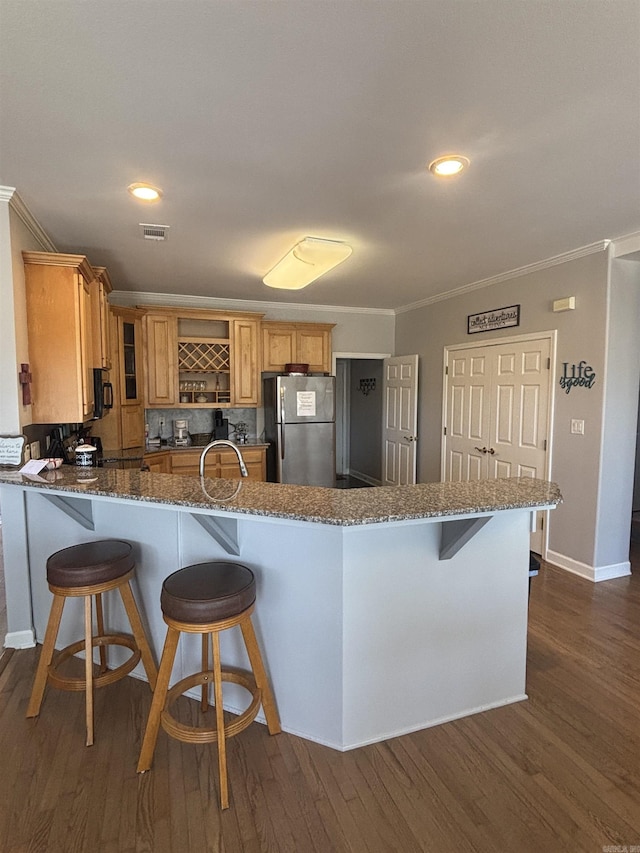 kitchen featuring visible vents, crown molding, a peninsula, freestanding refrigerator, and open shelves