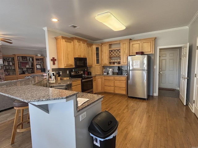 kitchen with visible vents, a sink, light wood-style floors, appliances with stainless steel finishes, and a peninsula